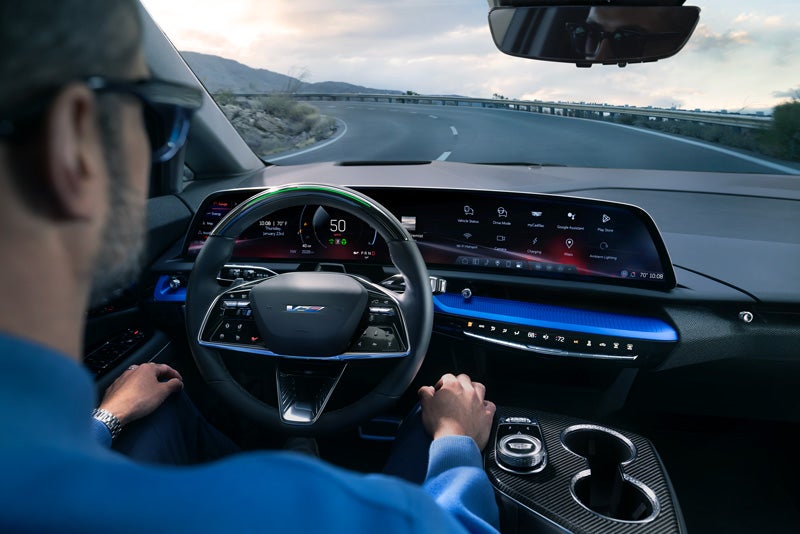 Front View of the 2026 OPTIQ-V Driving Through the Dusk Utilizing its Headlights | Peterson Cadillac in BOISE ID